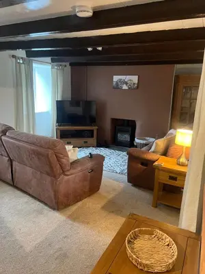 a living room with a couch and a television at 1 Carnebone Cottages in Porkellis