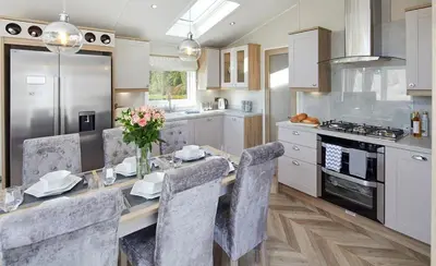 a kitchen with a dining table with chairs and a kitchen with white cabinets at Pool - Fireplace - 2Br Lodge - PetsOK - Parking in Newquay