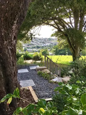 a garden with a tree and a stone pathway at Stunning getaway in Wadebridge, Cornwall in Wadebridge