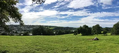 a field of green grass with a city in the distance at Stunning getaway in Wadebridge, Cornwall in Wadebridge