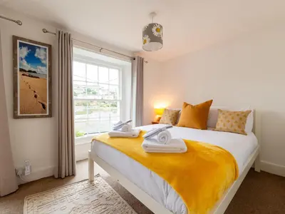 a bedroom with a large bed with towels on it at Holiday Home Elm Cottage by Interhome in Mevagissey