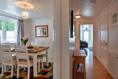 a dining room and living room with a table and chairs at Finest Retreats - Blue Horizon in St Ives