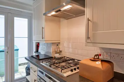 a kitchen with a stove top oven next to a window at Finest Retreats - Blue Horizon in St Ives