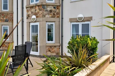 a patio with chairs and plants in front of a building at Finest Retreats - Blue Horizon in St Ives