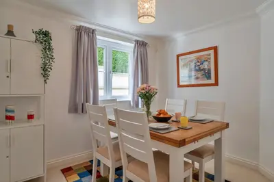 a kitchen and dining room with a wooden table and chairs at Finest Retreats - Blue Horizon in St Ives