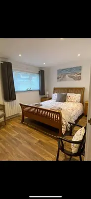 a bedroom with a large bed and a window at Seashells in Padstow