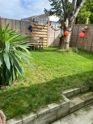 a backyard with a table and a tree and grass at Seashells in Padstow