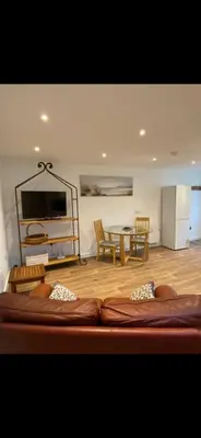 a living room with a bed and a table at Seashells in Padstow