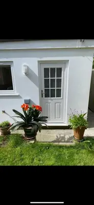 a white house with three potted plants in front of it at Seashells in Padstow