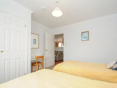 a bedroom with two beds and a desk at Bryher in Wadebridge