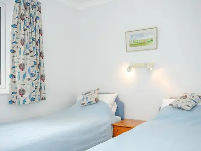 two beds in a room with white walls at Bryher in Wadebridge