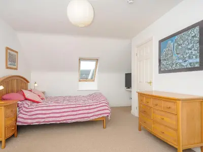 a bedroom with a bed and a wooden dresser at Bryher in Wadebridge
