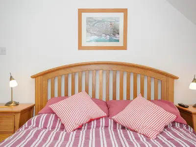 a bed with two pink and white pillows on it at Bryher in Wadebridge