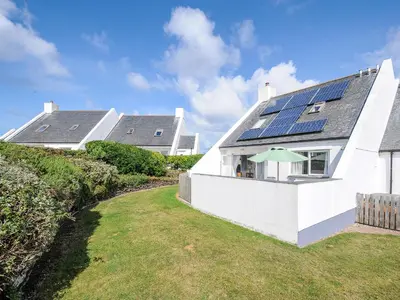 a white house with solar panels on the roof at Bryher in Wadebridge
