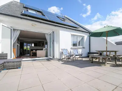 a patio with a table and an umbrella at Bryher in Wadebridge