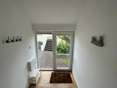 an empty hallway with a door to a patio at Newly renovated beach house on the coast in Saint Columb Minor