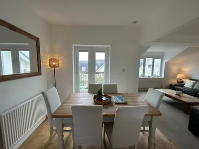a living room with a wooden table and chairs at Newly renovated beach house on the coast in Saint Columb Minor