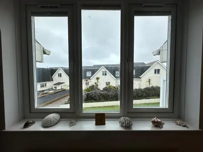 a window with a view of a house at Newly renovated beach house on the coast in Saint Columb Minor