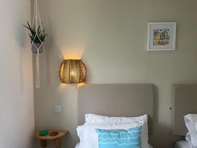 a bedroom with a bed with a light on the wall at Newly renovated beach house on the coast in Saint Columb Minor
