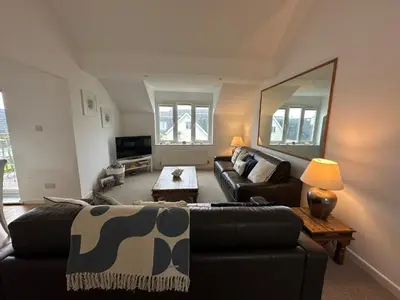 a living room with a couch and a table at Newly renovated beach house on the coast in Saint Columb Minor