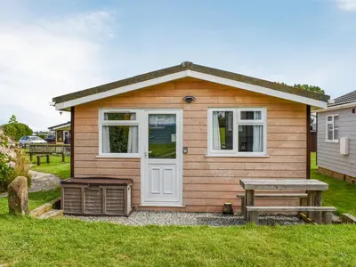 a small house with a picnic table and a bench at K2 Cosy Lodge in Padstow