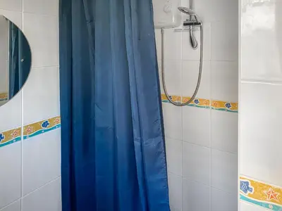 a shower with a blue shower curtain in a bathroom at K2 Cosy Lodge in Padstow