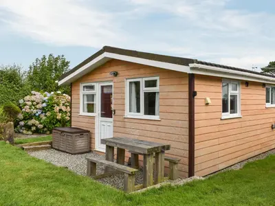 a small shed with a picnic table and a bench at K2 Cosy Lodge in Padstow