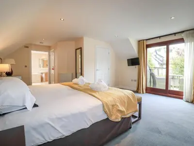 a large bedroom with a large bed and a large window at Clematis - Lodge 16 in Wadebridge