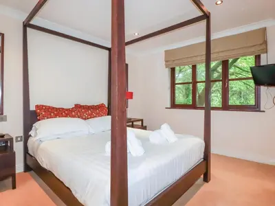 a bedroom with a four poster bed with white sheets at Clematis - Lodge 16 in Wadebridge