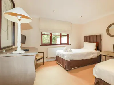 a bedroom with a bed and a desk with a lamp at Clematis - Lodge 16 in Wadebridge