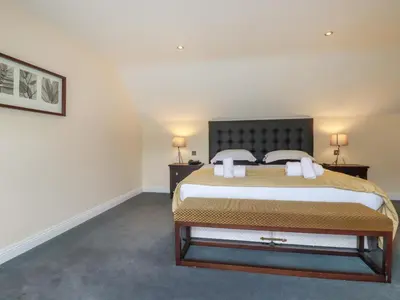 a bedroom with a large bed with two night stands at Clematis - Lodge 16 in Wadebridge