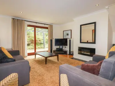 a living room with two couches and a television at Clematis - Lodge 16 in Wadebridge