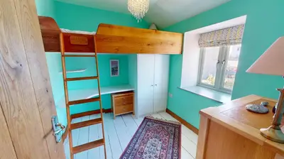 a room with a bunk bed and a desk at 1 St Ives Higher Ayr Cottage in St Ives