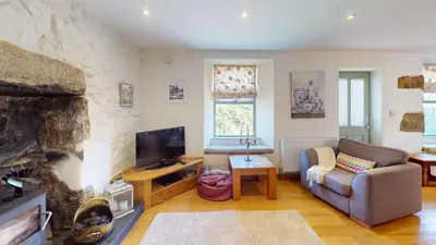 a living room with a couch and a fireplace at 1 St Ives Higher Ayr Cottage in St Ives