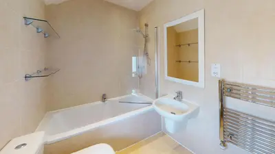 a bathroom with a tub and a sink and a toilet at 1 St Ives Higher Ayr Cottage in St Ives