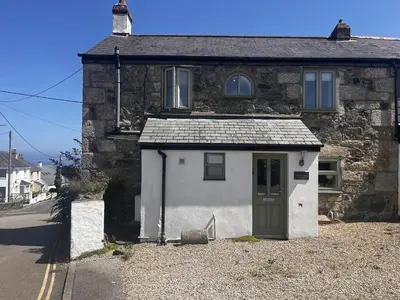 a small white house with a green door at 1 St Ives Higher Ayr Cottage in St Ives