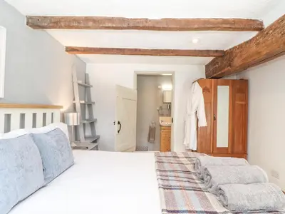 a bedroom with a white bed and a wooden ceiling at Skiber Coombe in Callington