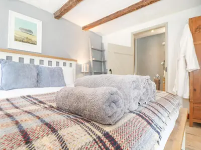 a bedroom with a bed with a blanket on it at Skiber Coombe in Callington