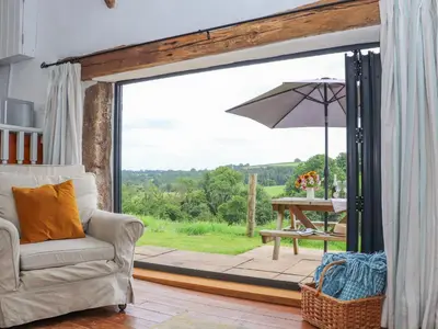 a living room with a sliding glass door with an umbrella at Skiber Long in Callington