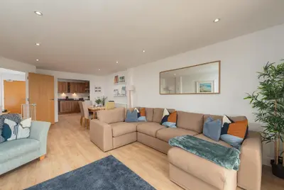 a living room with two couches and a kitchen at Host & Stay - Sunset in Newquay