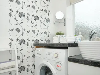 a laundry room with a washer and dryer at Coastal Haven in Bude