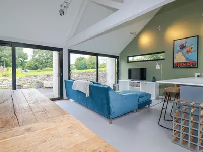 a living room with a blue couch and a table at The Old Watermill in Bodmin