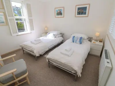 two twin beds in a room with two windows at Mariners Watch in St Ives