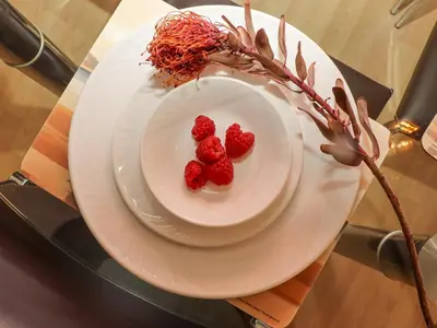 two raspberries on a plate on a table at Mariners Watch in St Ives