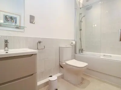 a white bathroom with a toilet and a sink at Mariners Watch in St Ives