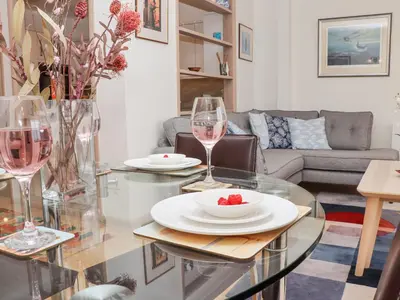 a living room with a table with two glasses of wine at Mariners Watch in St Ives