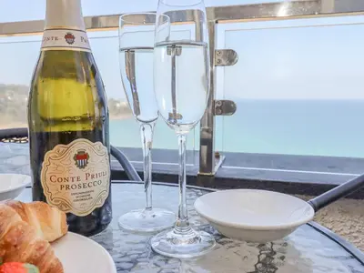 a bottle of wine and two glasses on a table at Mariners Watch in St Ives