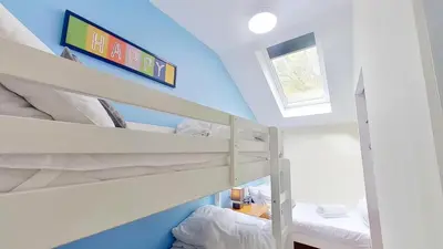 a bedroom with bunk beds with a blue wall at 06 Strawberry Hill, Tolroy Manor in Hayle