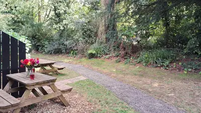 a picnic table with a vase of flowers on it at 06 Strawberry Hill, Tolroy Manor in Hayle