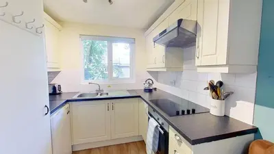 a kitchen with white cabinets and a sink at 06 Strawberry Hill, Tolroy Manor in Hayle